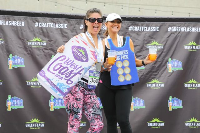 Craft Classic female runners at the podium with the photo frame and beer